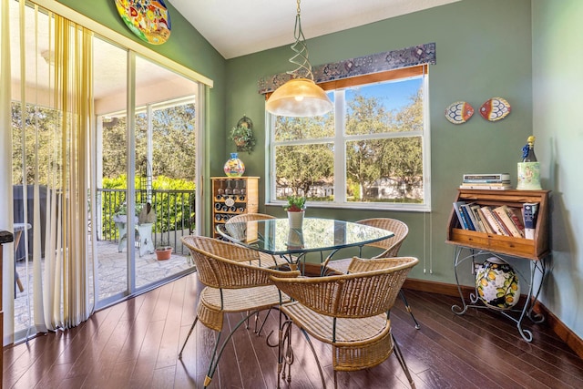 dining room with dark wood-type flooring and vaulted ceiling