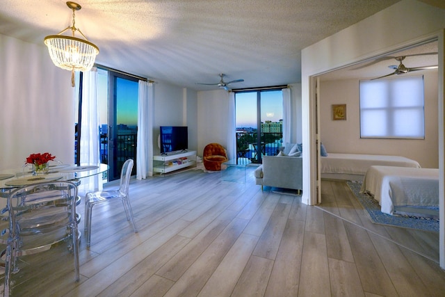 living room with a wealth of natural light, light hardwood / wood-style floors, and a textured ceiling