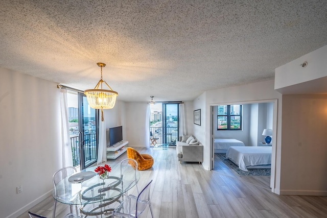 unfurnished dining area featuring a notable chandelier, a textured ceiling, and light hardwood / wood-style flooring