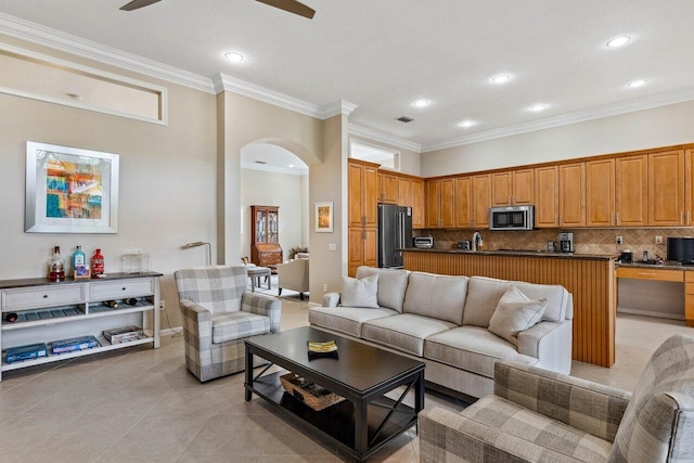 living room featuring ceiling fan, light tile patterned floors, and crown molding