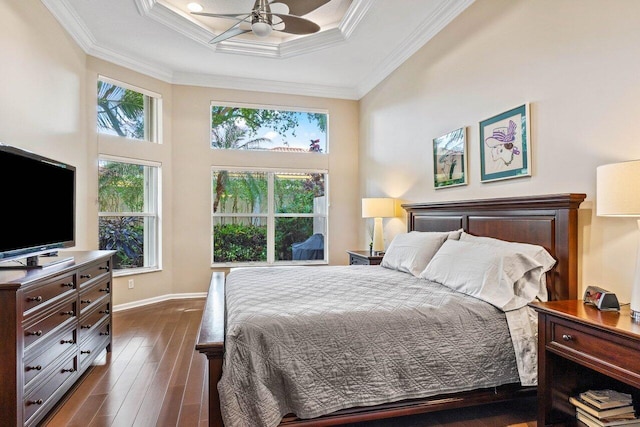 bedroom with ceiling fan, dark hardwood / wood-style flooring, ornamental molding, and multiple windows