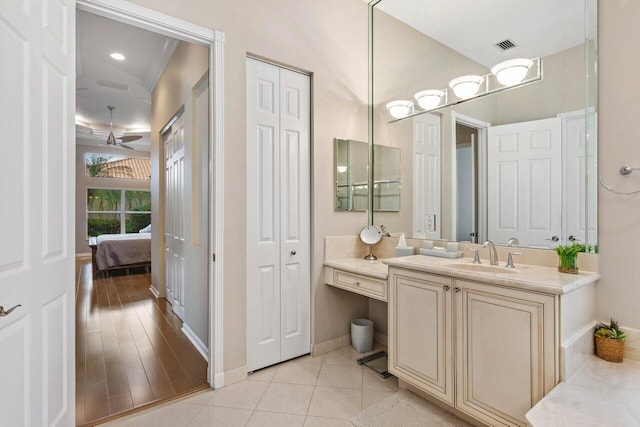 bathroom with hardwood / wood-style floors, ceiling fan, ornamental molding, and vanity