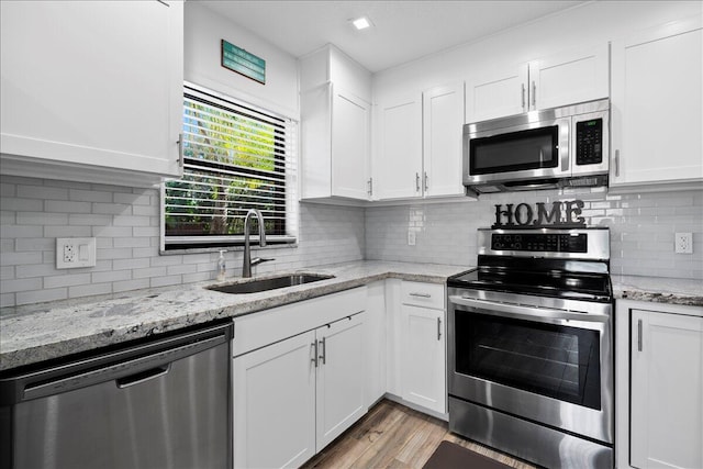 kitchen featuring white cabinetry, sink, appliances with stainless steel finishes, and light hardwood / wood-style flooring