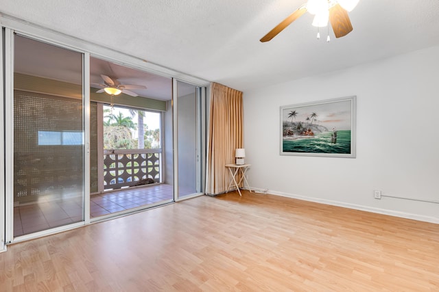 unfurnished room with ceiling fan, light hardwood / wood-style floors, and a textured ceiling