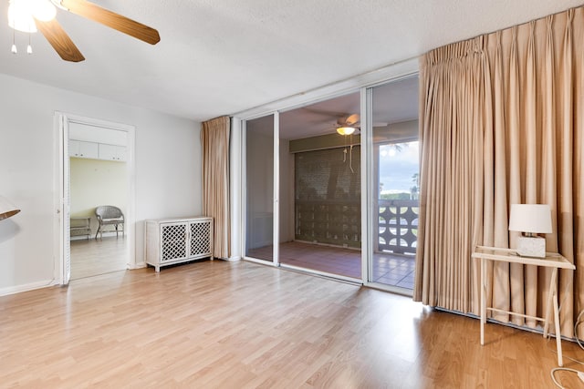 interior space with ceiling fan, wood-type flooring, and a textured ceiling