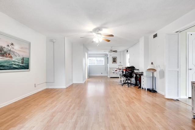 office space featuring ceiling fan, light hardwood / wood-style flooring, and a textured ceiling