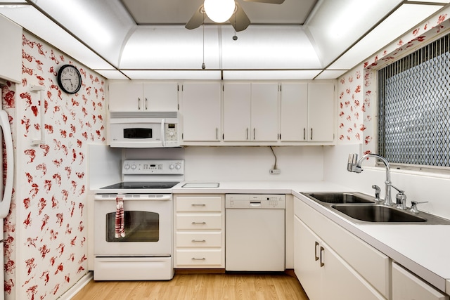 kitchen featuring white cabinetry, sink, white appliances, and light wood-type flooring