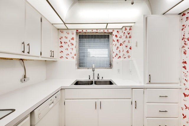 kitchen with dishwasher, white cabinetry, and sink