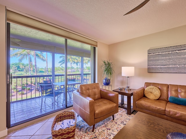 tiled living room featuring ceiling fan and a textured ceiling