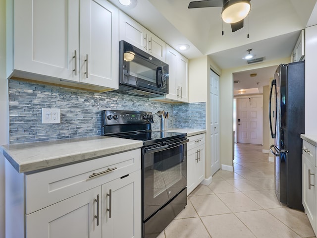 kitchen with backsplash, black appliances, white cabinets, light stone countertops, and light tile patterned floors