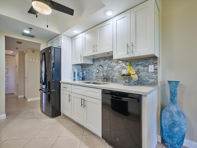 kitchen with tasteful backsplash, sink, black appliances, light tile patterned floors, and white cabinetry