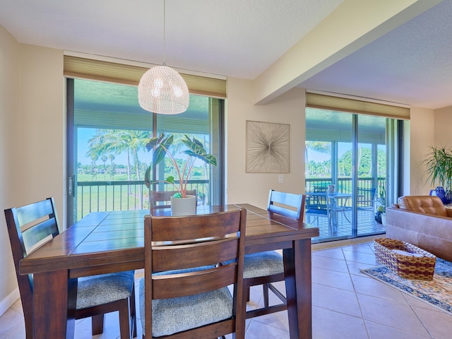 tiled dining area featuring plenty of natural light, floor to ceiling windows, and a textured ceiling