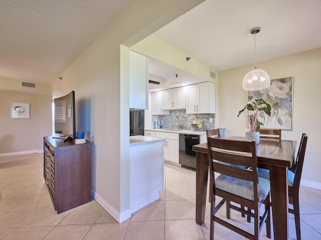 kitchen featuring sink, white cabinets, hanging light fixtures, and black dishwasher