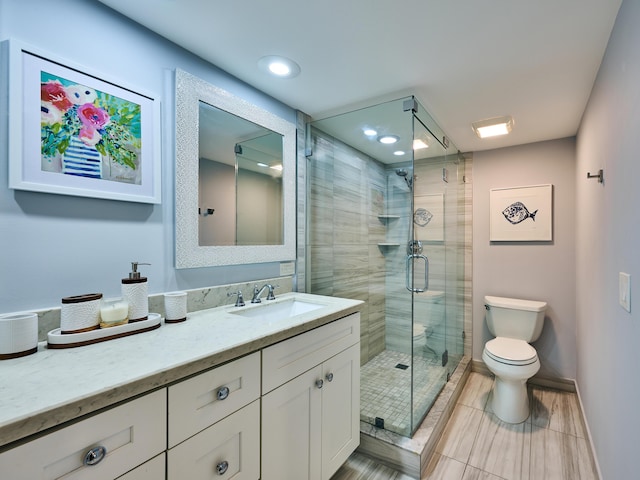 bathroom featuring an enclosed shower, vanity, and toilet