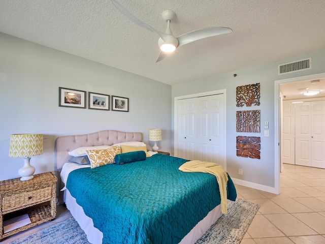 tiled bedroom featuring ceiling fan, a closet, and a textured ceiling