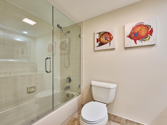 bathroom with toilet and bath / shower combo with glass door