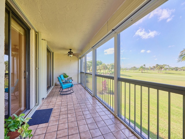 unfurnished sunroom with ceiling fan