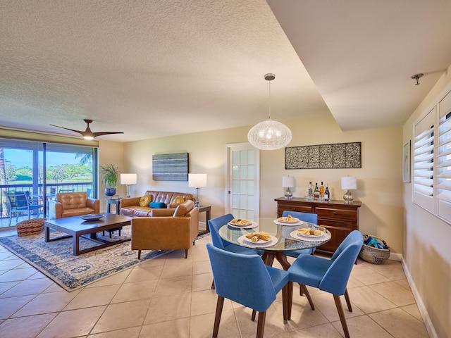 tiled dining area featuring ceiling fan and a textured ceiling