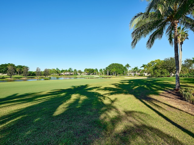 view of property's community with a water view and a yard