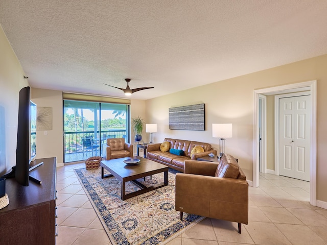 living room with ceiling fan, light tile patterned floors, and a textured ceiling