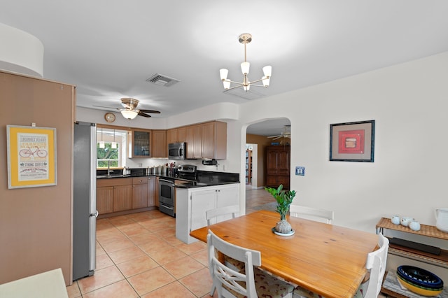 kitchen featuring appliances with stainless steel finishes, ceiling fan with notable chandelier, sink, pendant lighting, and light tile patterned flooring