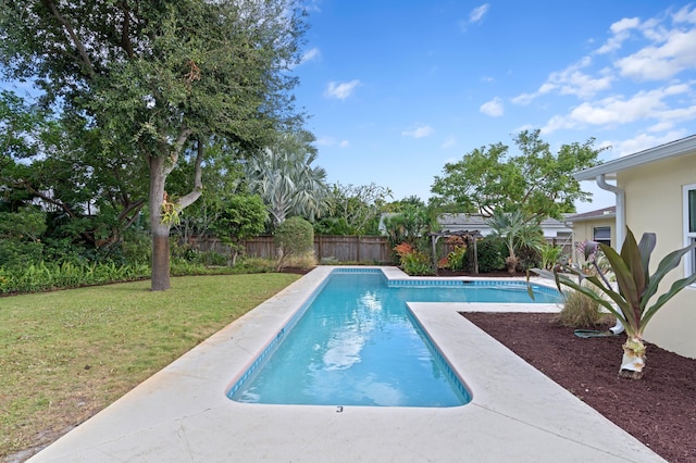 view of swimming pool with a yard