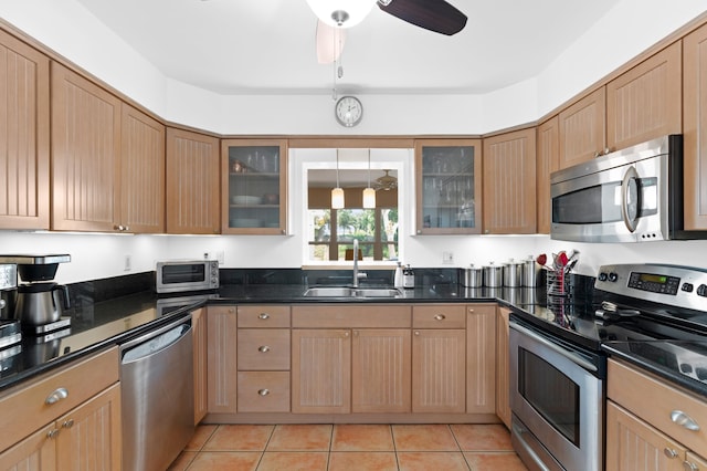 kitchen featuring ceiling fan, sink, light tile patterned floors, and stainless steel appliances