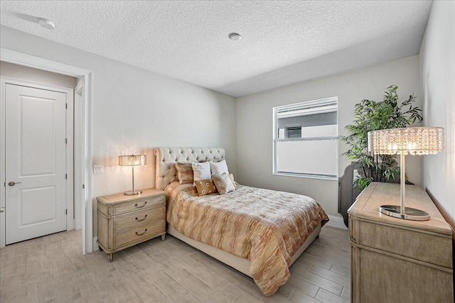 bedroom featuring a textured ceiling and light wood-style floors