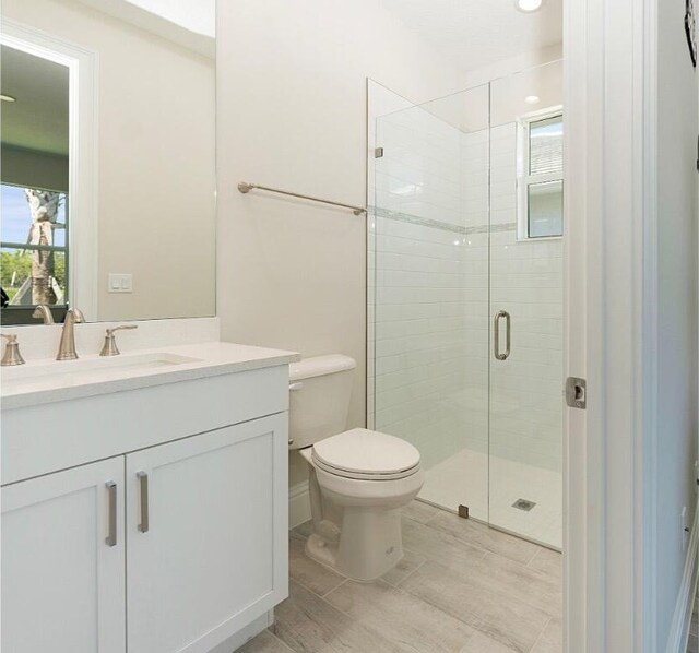 bathroom featuring visible vents, toilet, wood finished floors, baseboards, and vanity