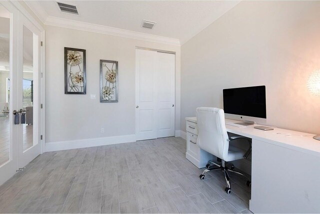 office area featuring a textured ceiling, baseboards, crown molding, and light wood-style floors