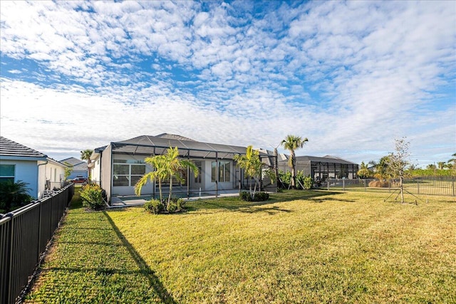 exterior space featuring a lawn, glass enclosure, and a fenced backyard