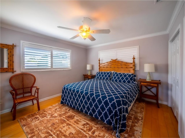 bedroom featuring crown molding, ceiling fan, a closet, and wood-type flooring