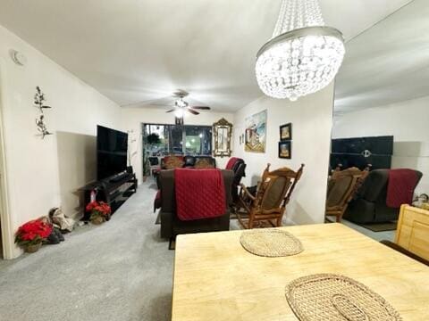 dining room with carpet flooring and ceiling fan with notable chandelier