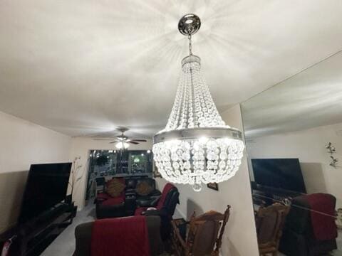 living room featuring ceiling fan with notable chandelier