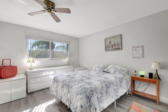 bedroom with ceiling fan and wood-type flooring