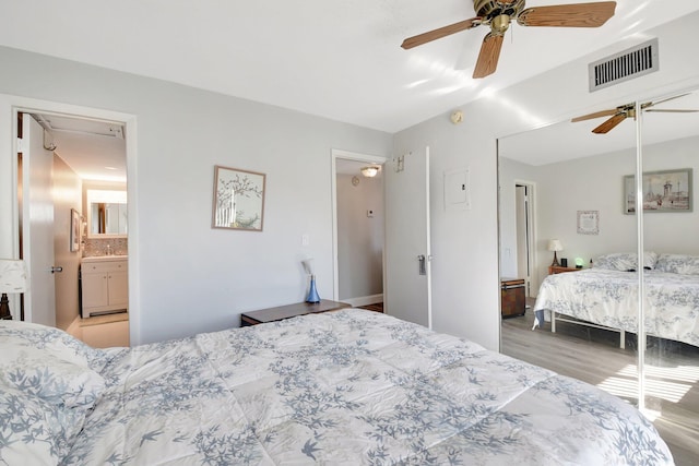 bedroom with connected bathroom, ceiling fan, and light wood-type flooring