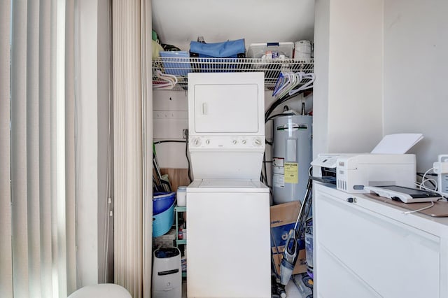 laundry area with electric water heater and stacked washer / drying machine