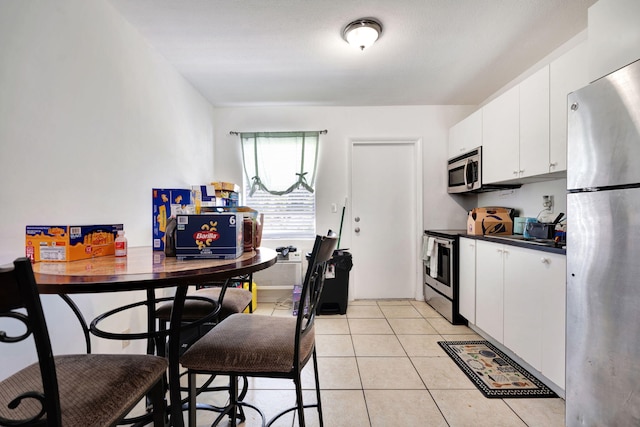 kitchen featuring white cabinetry, light tile patterned floors, and appliances with stainless steel finishes