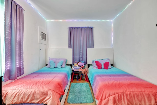 bedroom featuring hardwood / wood-style floors and a wall unit AC