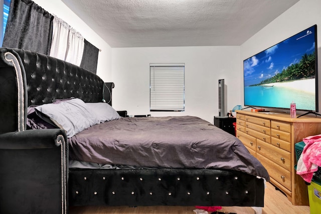 bedroom featuring wood-type flooring and a textured ceiling