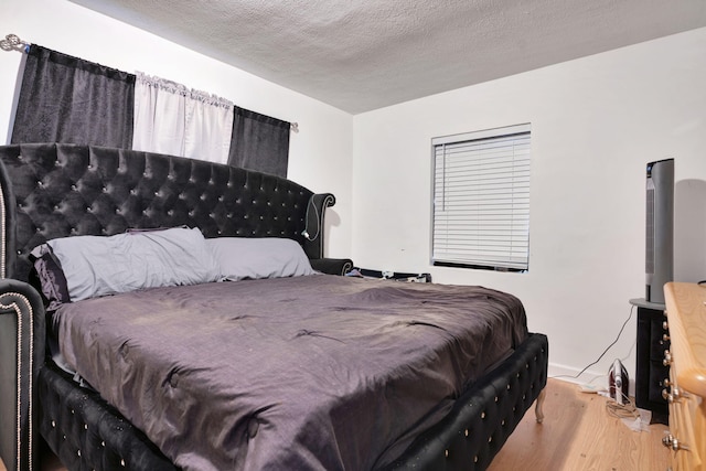 bedroom featuring wood-type flooring and a textured ceiling