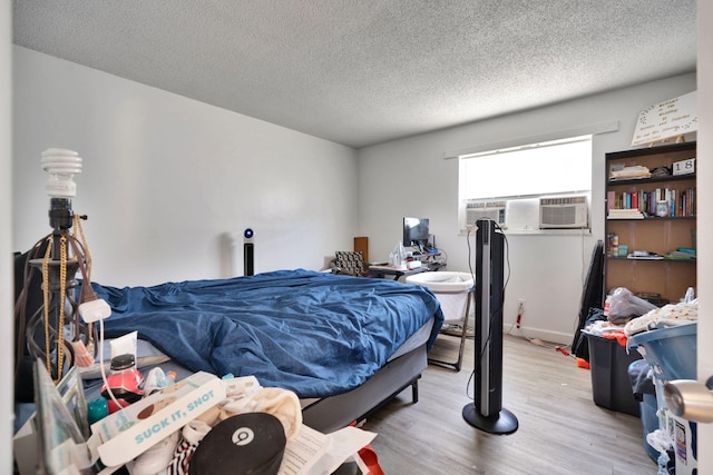 bedroom with a textured ceiling and light hardwood / wood-style floors