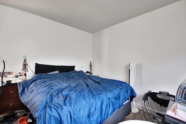 bedroom featuring wood-type flooring and a textured ceiling