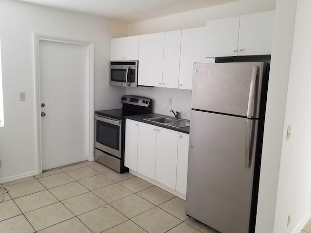 kitchen featuring sink, white cabinets, light tile patterned floors, and appliances with stainless steel finishes