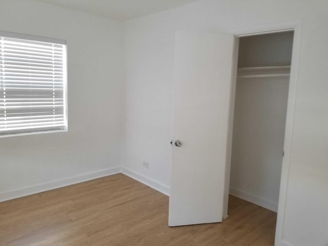 unfurnished bedroom featuring light wood-type flooring and a closet