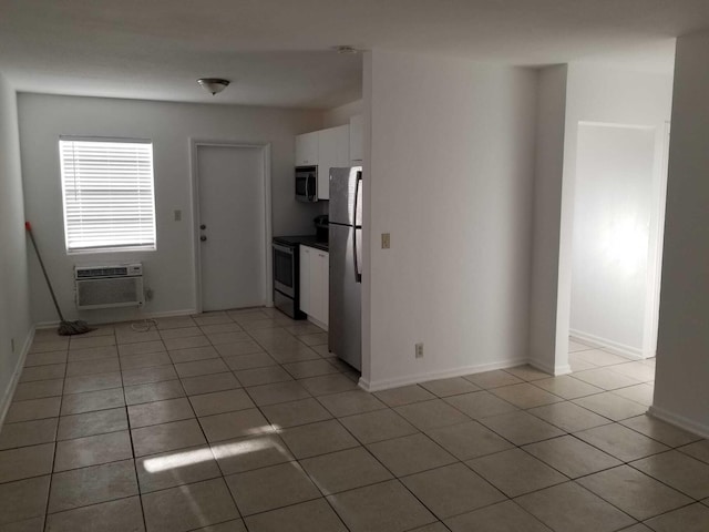 interior space with appliances with stainless steel finishes, white cabinetry, a wall mounted AC, and light tile patterned flooring