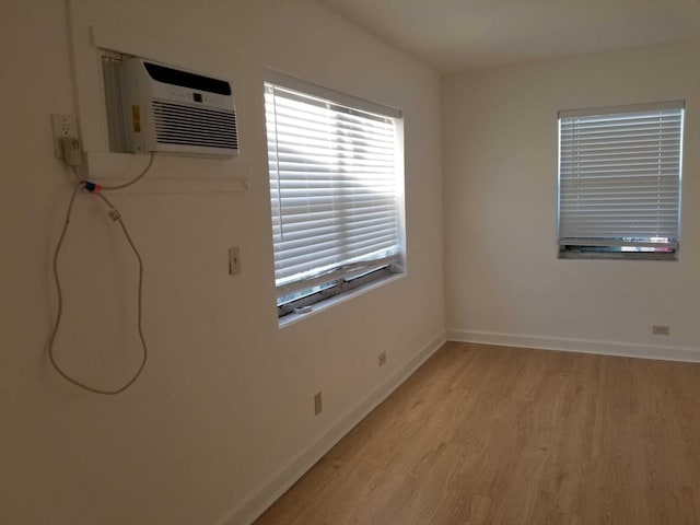 empty room featuring light hardwood / wood-style floors and a wall unit AC