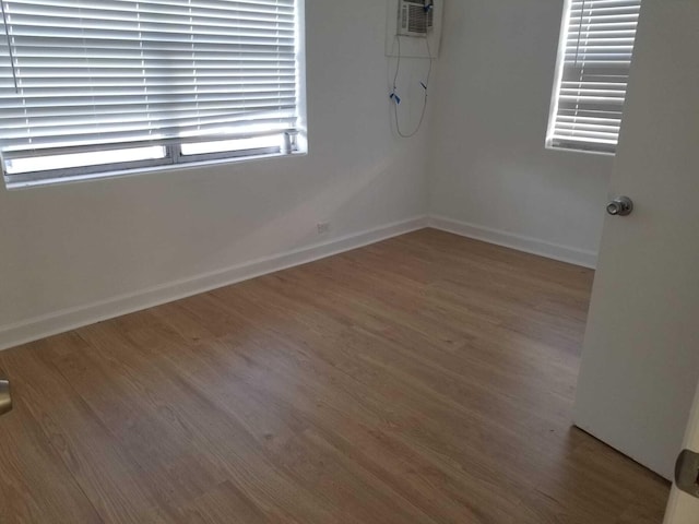 spare room with hardwood / wood-style floors and a wall mounted air conditioner