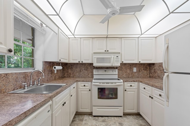 kitchen with white appliances, white cabinets, and sink