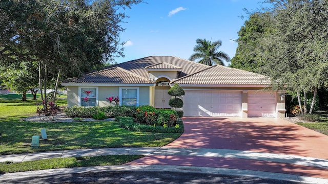 mediterranean / spanish house with a garage and a front lawn